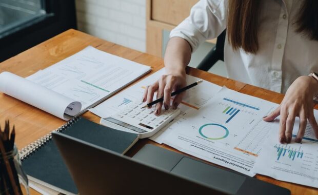 accountant woman checking paperwork from accounting department to analyse number on document