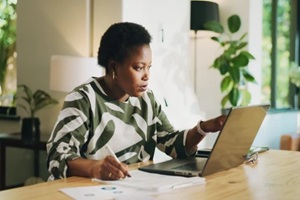 bookkeeping, writing or black woman with laptop in home for account review, audit or tax returns