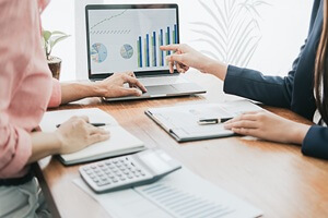 Business people discussing the charts and graphs showing the results of their successful teamwork