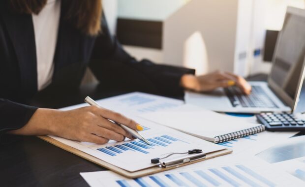 business woman working on an audit using laptop at her desk in the office