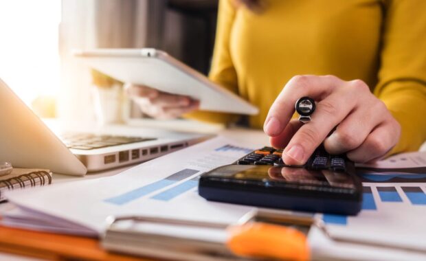 business women using calculator with computer laptop