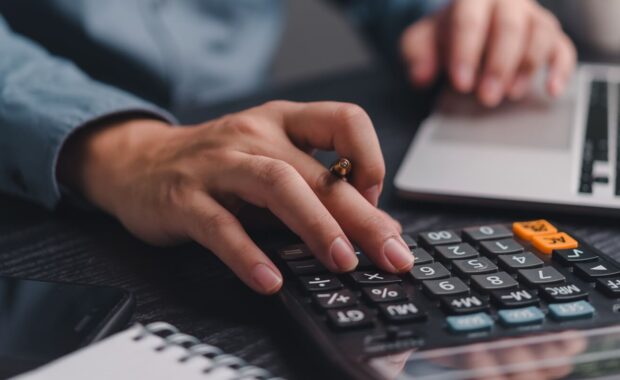 Businessman using calculator bookkeeping payroll and budget tax