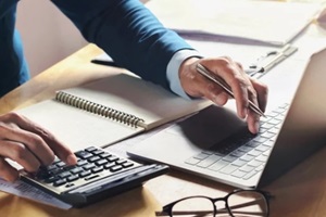 businessman working on desk with using calculator and computer in office