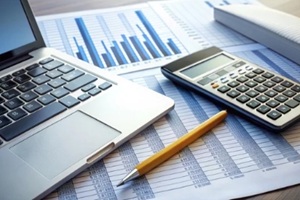 calculator and pencil rest on a financial report