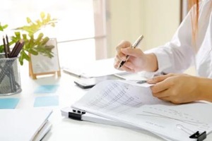 Close up audit woman calculate on paper document financial data