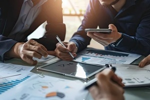 flawless image of people discussing project drafts on tablet in office