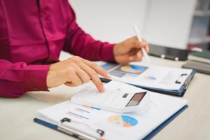 focused man works diligently in his office, reviewing numerous accounting documents on his desk