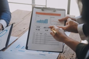 investor colleagues discussing new plan financial graph data on office table with laptop and digital tablet