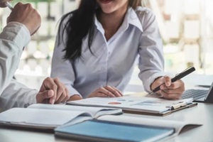 male business consultant describes a marketing plan to set business strategies for women business owners witch using tablet