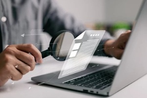man inspecting paperwork with magnifier