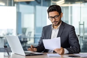 portrait of serious pensive businessman behind paperwork