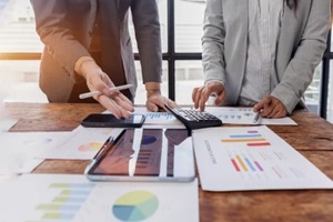 team working at office, using calculator to calculate company finance, accounting with laptop computer on table